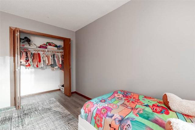 bedroom featuring a closet, light hardwood / wood-style floors, and lofted ceiling