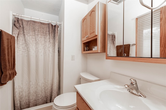 bathroom featuring curtained shower, a textured ceiling, vanity, and toilet