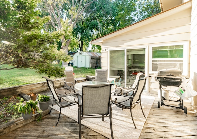 deck with a storage shed and area for grilling