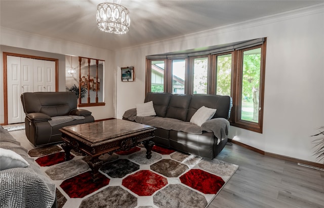 living room featuring light hardwood / wood-style flooring, a chandelier, and ornamental molding