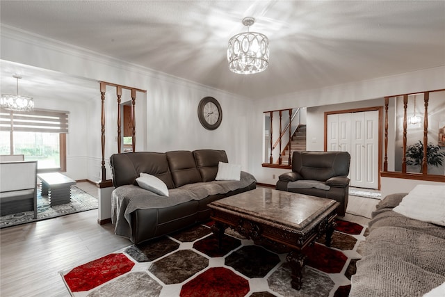 living room with ornamental molding, a chandelier, and hardwood / wood-style flooring