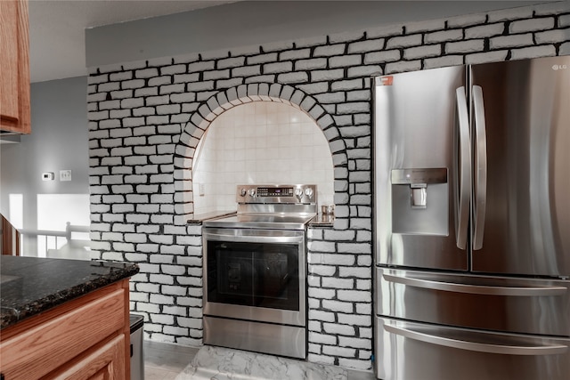 kitchen with backsplash, dark stone countertops, and stainless steel appliances