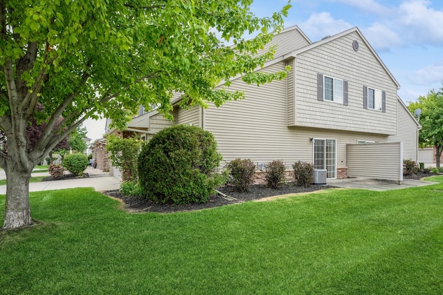 view of side of home with central AC and a yard