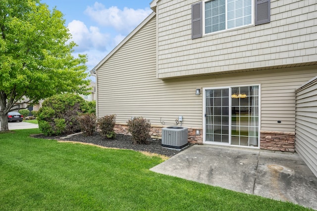 back of property with a yard, central air condition unit, and a patio area