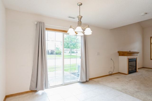 carpeted empty room featuring a notable chandelier