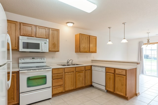 kitchen with light tile patterned flooring, white appliances, kitchen peninsula, decorative light fixtures, and sink