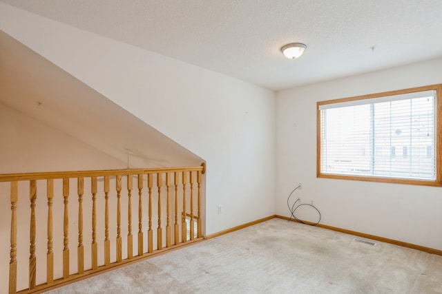 empty room featuring a textured ceiling and carpet