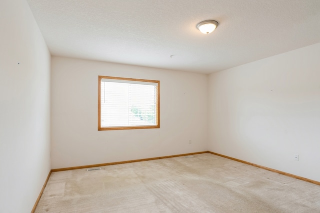 carpeted spare room with a textured ceiling