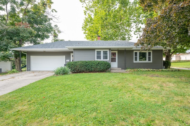 ranch-style house with a garage and a front lawn