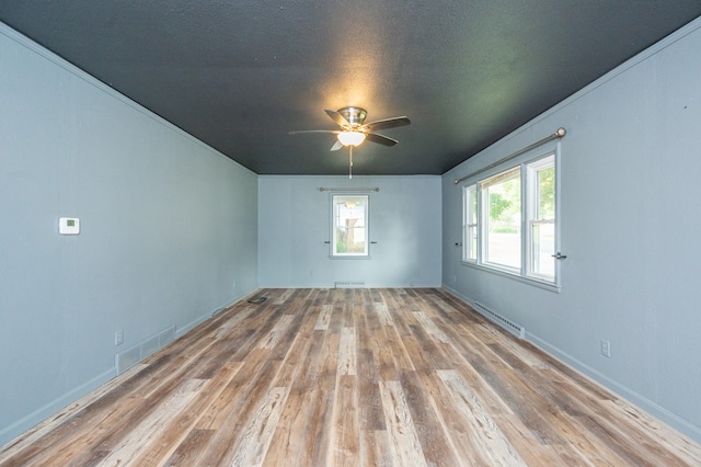 unfurnished room with light wood-type flooring, a textured ceiling, a baseboard heating unit, and ceiling fan