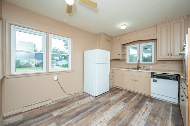 kitchen with sink, white appliances, baseboard heating, hardwood / wood-style floors, and ceiling fan