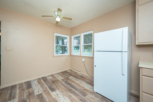 kitchen featuring light hardwood / wood-style floors, white refrigerator, white cabinetry, a baseboard radiator, and ceiling fan