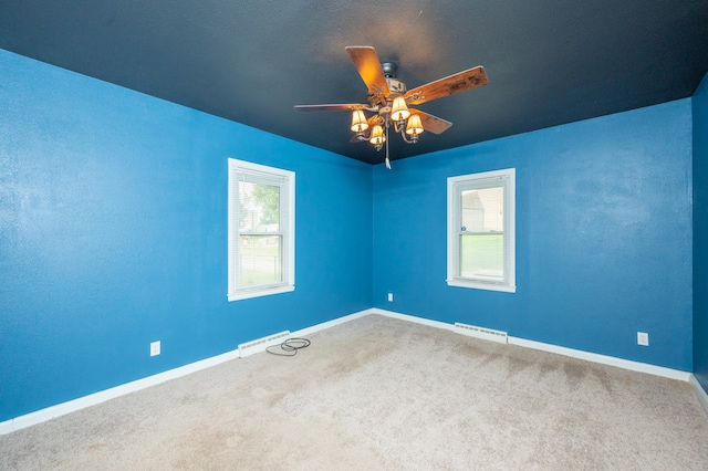 carpeted spare room with ceiling fan and a healthy amount of sunlight