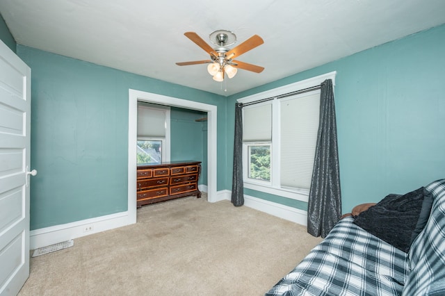 sitting room featuring light colored carpet, plenty of natural light, and ceiling fan