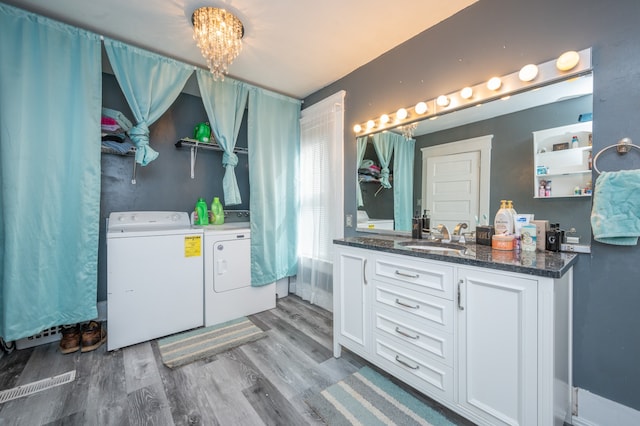 interior space featuring vanity, a notable chandelier, hardwood / wood-style floors, and separate washer and dryer