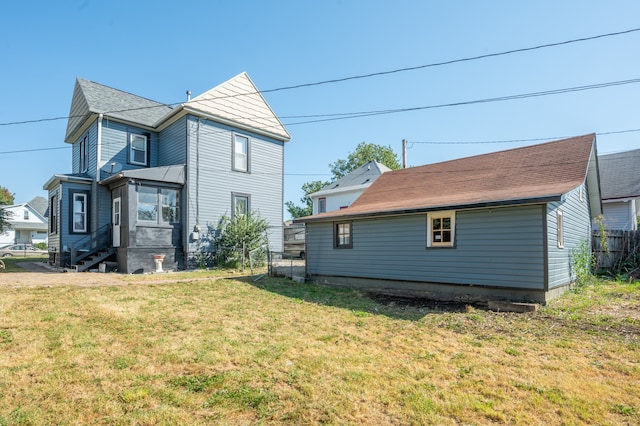 rear view of property with a lawn