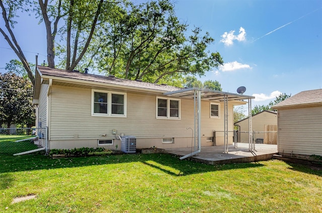 rear view of house with central AC, a patio area, and a lawn