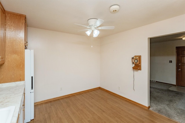 unfurnished room featuring light wood-type flooring and ceiling fan