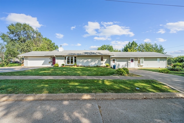 ranch-style home featuring a garage and a front lawn