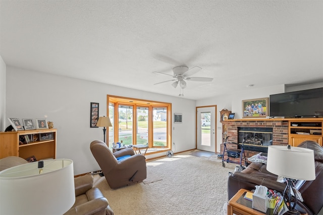 carpeted living room featuring a textured ceiling, a fireplace, and ceiling fan