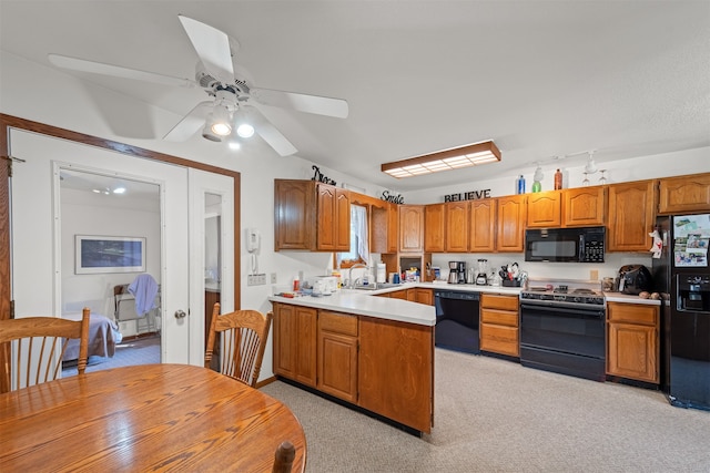 kitchen featuring ceiling fan, light carpet, sink, and black appliances