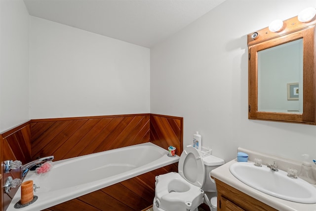 bathroom featuring vanity, toilet, and a washtub