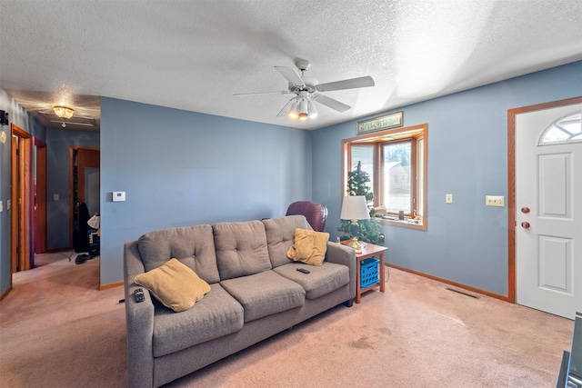 living room with a textured ceiling, carpet flooring, and ceiling fan