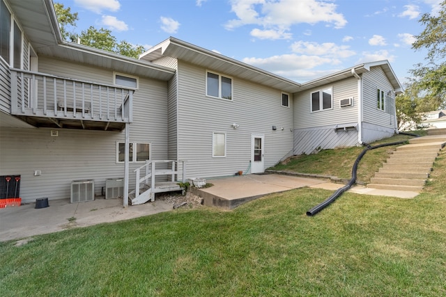 rear view of property with a lawn, central AC, and a patio area