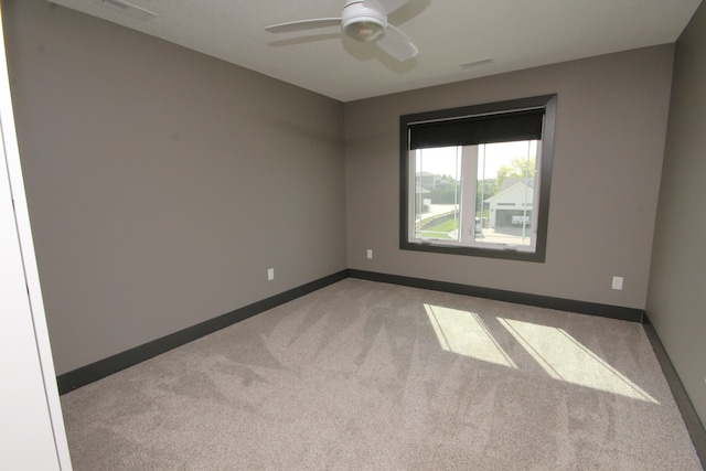 carpeted spare room featuring ceiling fan