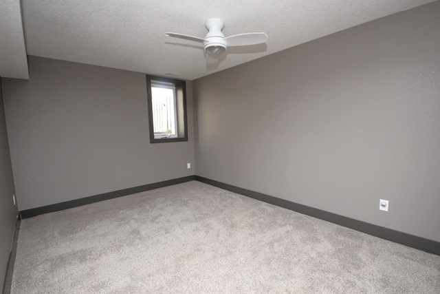 carpeted spare room featuring a textured ceiling and ceiling fan