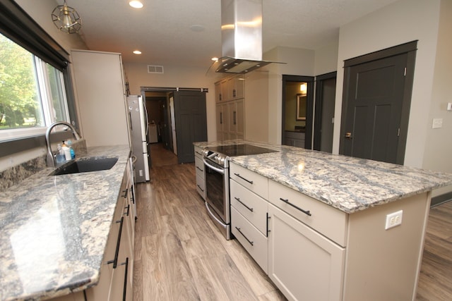 kitchen featuring white cabinetry, light stone counters, a kitchen island, island exhaust hood, and sink