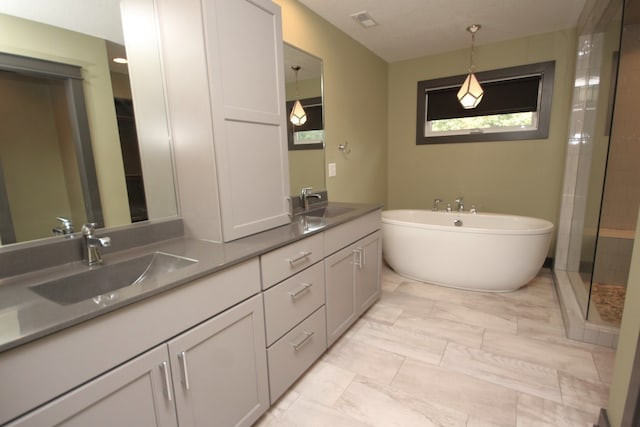 bathroom with vanity and shower with separate bathtub