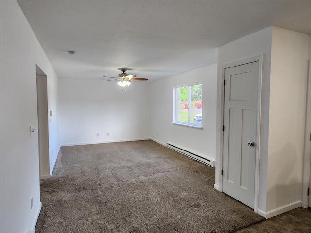 spare room featuring ceiling fan, a baseboard heating unit, and dark colored carpet