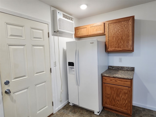 kitchen featuring an AC wall unit and white fridge with ice dispenser