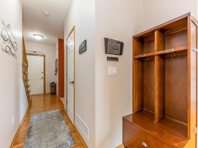 corridor with light wood-type flooring and elevator