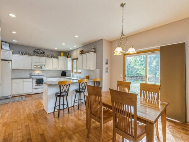 dining room featuring a notable chandelier and light hardwood / wood-style flooring