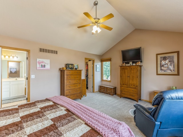 carpeted bedroom featuring ceiling fan, connected bathroom, a walk in closet, a closet, and vaulted ceiling