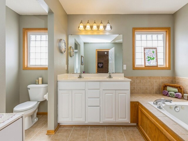 bathroom with a tub to relax in, plenty of natural light, vanity, and toilet