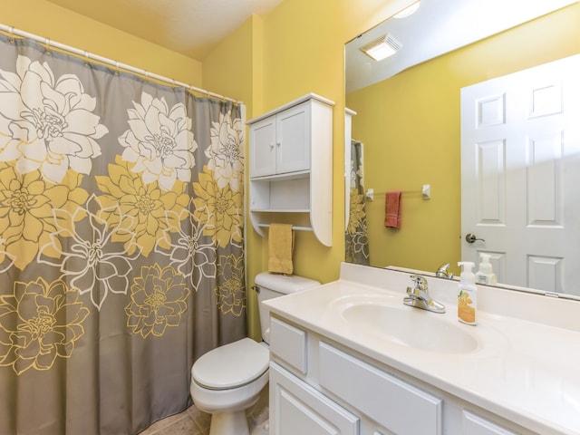 bathroom with tile patterned flooring, vanity, and toilet