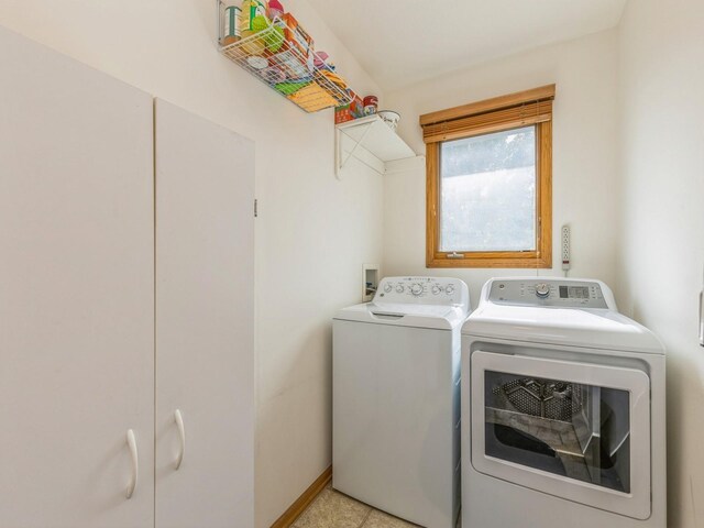 laundry room featuring washer and clothes dryer and light tile patterned floors