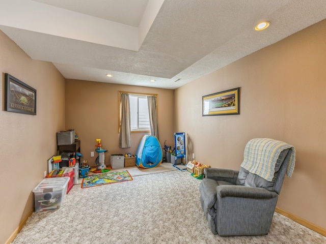 rec room featuring a textured ceiling and carpet