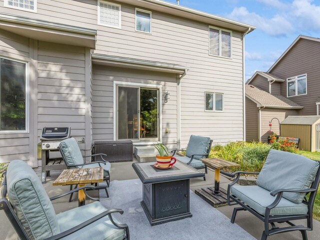 view of patio with a grill, a shed, and a fire pit