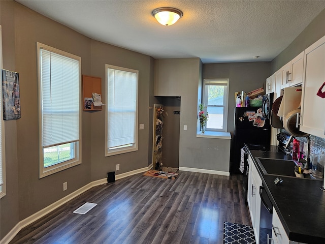 kitchen with a textured ceiling, dark hardwood / wood-style floors, sink, white cabinetry, and black appliances