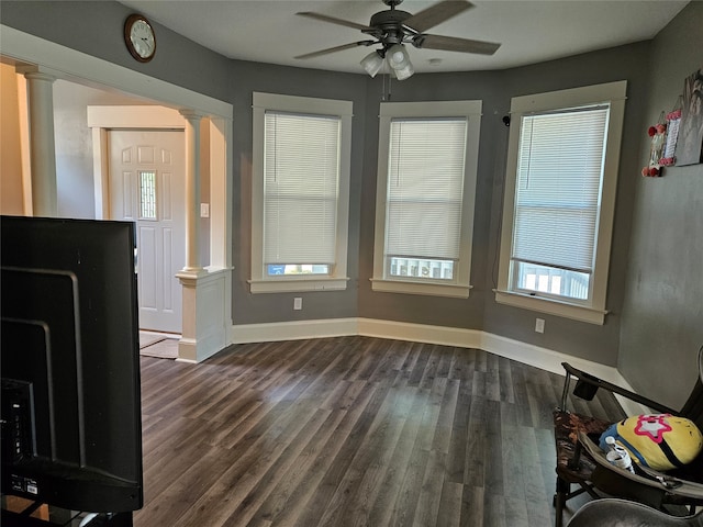 unfurnished office with ceiling fan, dark hardwood / wood-style floors, and decorative columns