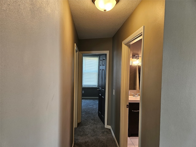 hallway featuring a textured ceiling and carpet