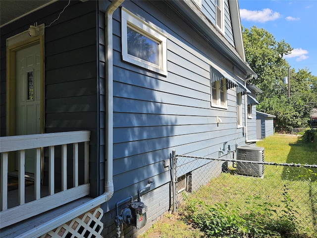 view of side of property with central AC unit and a yard