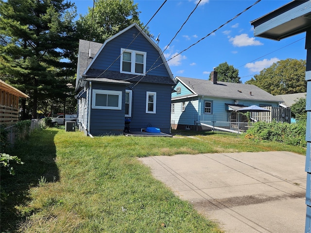 rear view of house featuring a deck, a yard, and central air condition unit