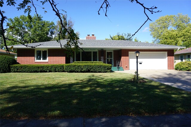 single story home with a garage and a front lawn