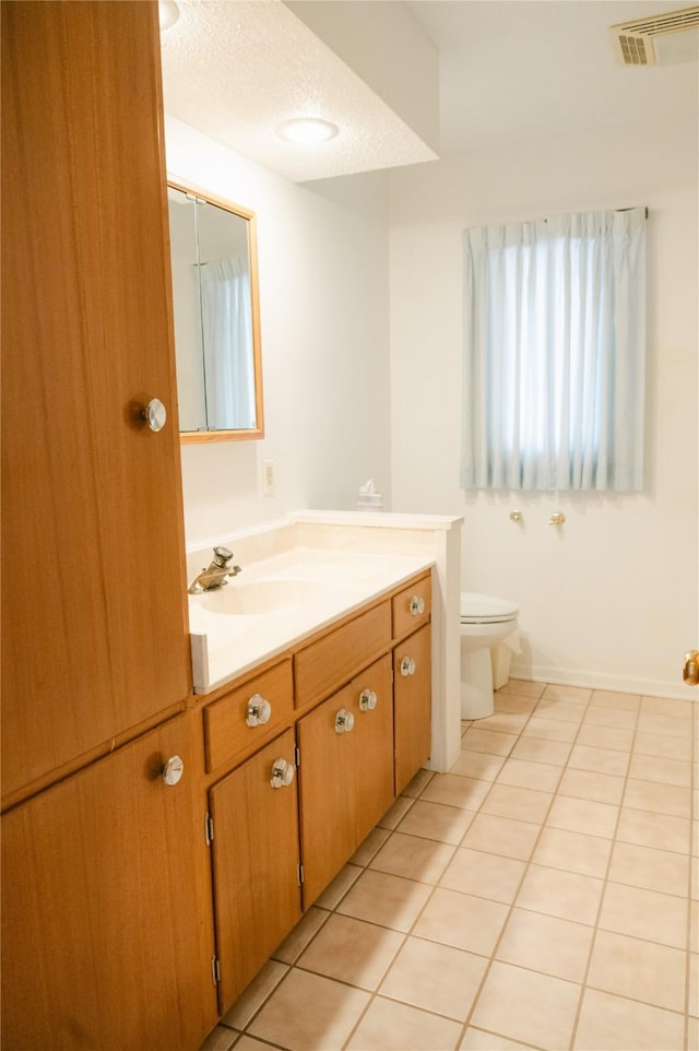 bathroom with visible vents, toilet, a textured ceiling, tile patterned flooring, and vanity