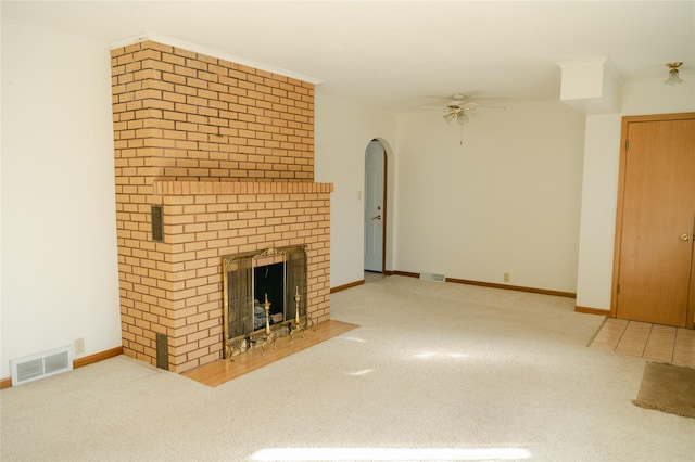 unfurnished living room featuring a fireplace, crown molding, carpet, and visible vents